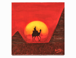 Camel rider moving towards setting sun